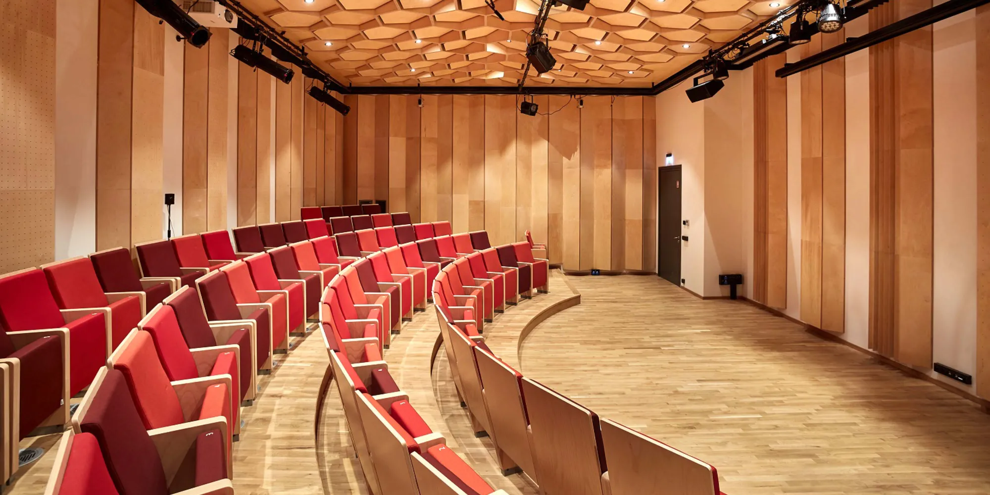 kantoor-nowystyl-theaterstoelen-2000x1000px3 Een foto van een collegezaal met houten Nowy Styl collegestoelen met rode zitting